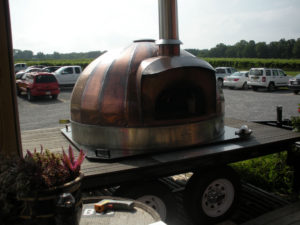 A pizza oven on the back of a trailer.