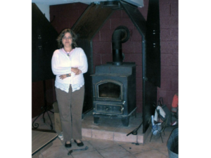 A woman standing in front of an old stove.