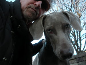 A man and his dog are posing for the camera.
