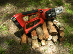 A red and black electric saw on some wood