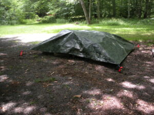 A tarp is set up to protect the tent from rain.