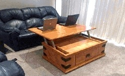 A coffee table with two laptops on top of it.