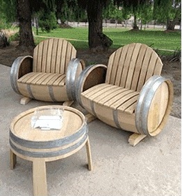 A couple of chairs made out of wine barrels.