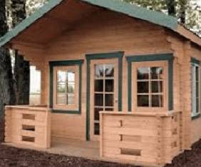 A wooden cabin with green trim and a porch.