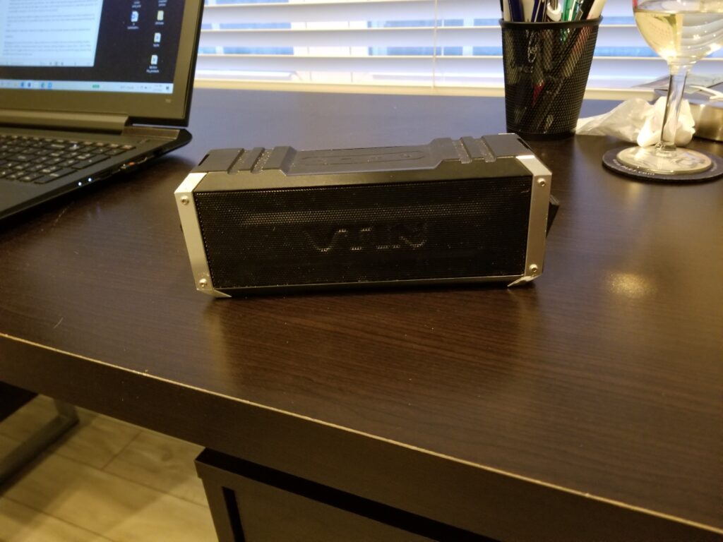 small black portable speaker sitting on a desktop