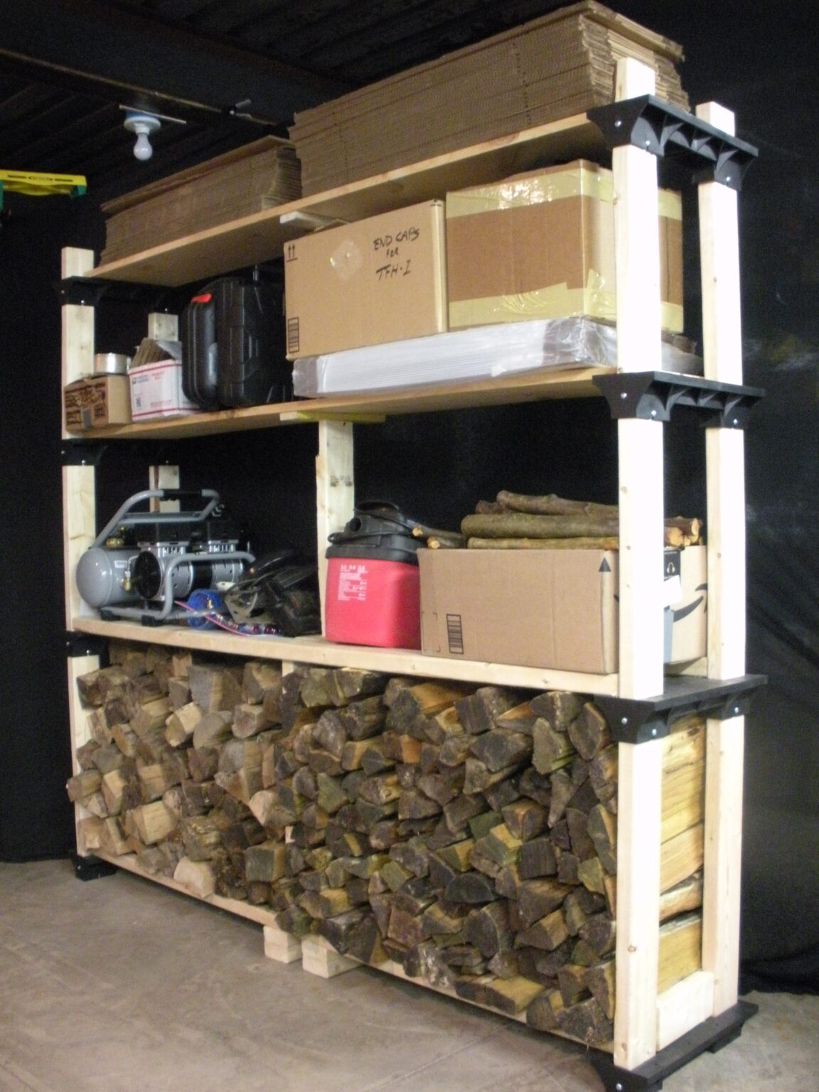 firewood stacked indoors on a custom built 2x4 shelf in a basement workroom.