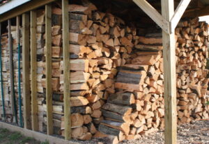 stacks of split firewood stored under cover of a roof